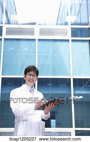 A doctor holding a report a modern building View Large Photo Image Stock Photo - A doctor holding a report a modern building. Fotosearch
