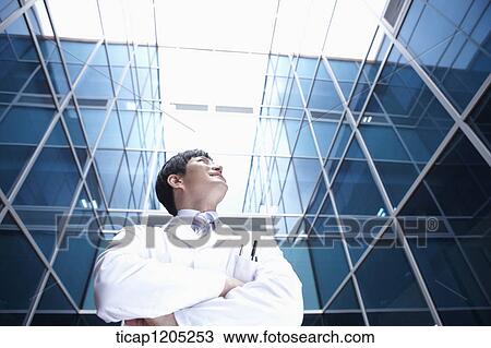 A doctor in a modern building with arms crossed View Large Photo Image Stock Image - A doctor in a modern building with arms crossed. Fotosearch