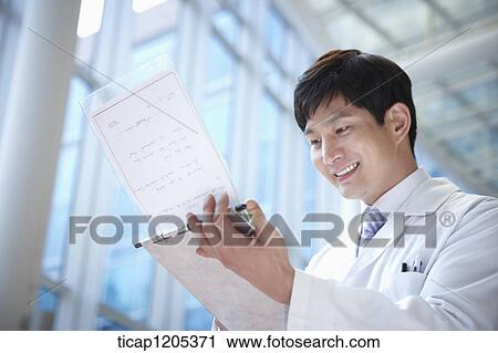 A doctor in a white dressing gown smiling at a report in his hands View Large Photo Image Stock Image - A doctor in a white dressing gown smiling at a report in his hands. Fotosearch