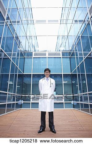 Stock Photo - A doctor standing in middle of a modern building. Fotosearch