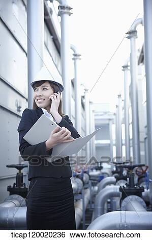 A female architect answering a radio receiver View Large Photo Image Stock Photograph - A female architect answering a radio receiver. Fotosearch