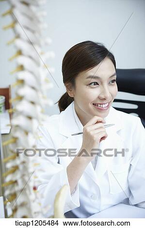 A female surgeon smiling in her office View Large Photo Image Picture - A female surgeon smiling in her office. Fotosearch