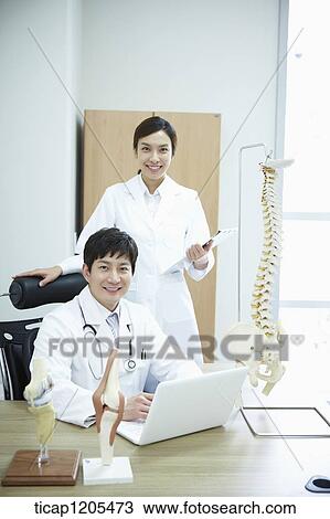 A female surgeon standing next to a male surgeon View Large Photo Image Stock Image - A female surgeon standing next to a male surgeon. Fotosearch
