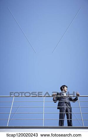 Stock Image - A man holding a fence . Fotosearch