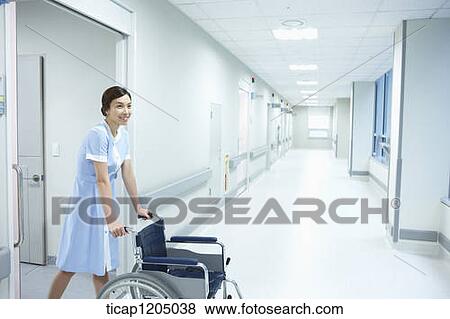 A nurse exiting a room with an empty wheelchair to an empty hospital corridor View Large Photo Image Stock Photo - A nurse exiting a room with an empty wheelchair to an empty hospital corridor. Fotosearch
