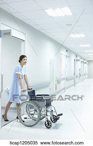 A nurse exiting a room with an empty wheelchair smiling View Large Photo Image Stock Photography - A nurse exiting a room with an empty wheelchair smiling. Fotosearch