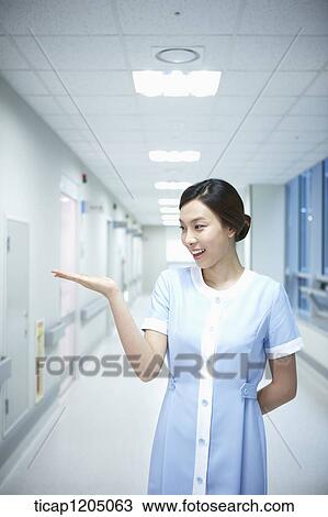 A nurse standing in an empty hospital corridor with a hand gesture View Large Photo Image Stock Image - A nurse standing in an empty hospital corridor with a hand gesture. Fotosearch