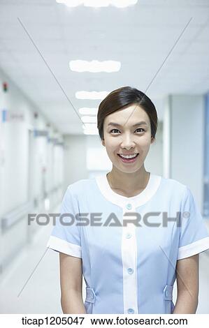 A nurse standing in an empty hospital corridor View Large Photo Image Stock Photo - A nurse standing in an empty hospital corridor. Fotosearch