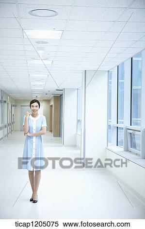A nurse standing next to windows in an empty hospital corridor View Large Photo Image Stock Photography - A nurse standing next to windows in an empty hospital corridor. Fotosearch