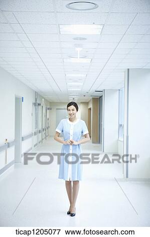 A nurse standing politely next of windows in an empty hospital corridor View Large Photo Image Stock Photo - A nurse standing politely next of windows in an empty hospital corridor. Fotosearch