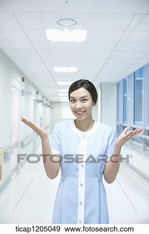 A nurse using hand gesture in an empty corridor View Large Photo Image Stock Photo - A nurse using hand gesture in an empty corridor. Fotosearch
