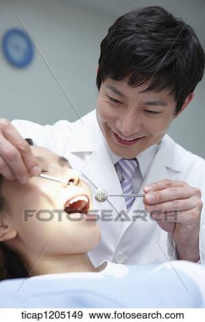 Stock Photo - A patient having a dental treatment. Fotosearch