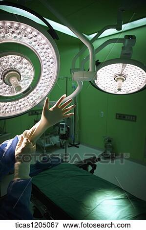 A surgeon wearing medical gloves in operating room View Large Photo Image Stock Photo - A surgeon wearing medical gloves in operating room . Fotosearch