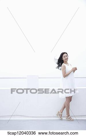 A woman in a white dress next to a white fence View Large Photo Image Stock Photograph - A woman in a white dress next to a white fence. Fotosearch