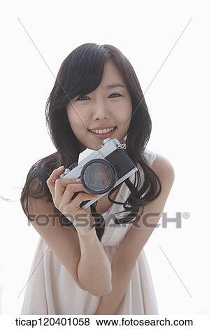 A woman in white dress and wavy hair smiling with a retro camera in her hand View Large Photo Image Stock Photo - A woman in white dress and wavy hair smiling with a retro camera in her hand. Fotosearch