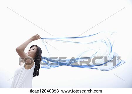A woman in white dress holding up a thin transparent blue linen View Large Photo Image Stock Image - A woman in white dress holding up a thin transparent blue linen. Fotosearch