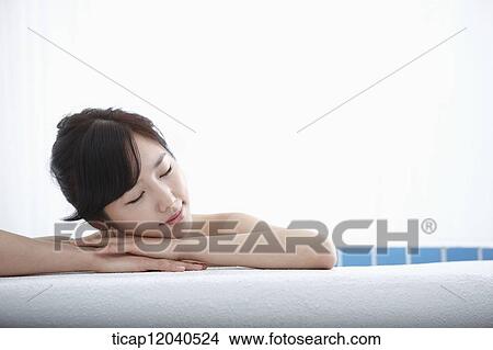 A woman leaning on a edge of bathtub in a bathtub with eyes closed View Large Photo Image Picture - A woman leaning on a edge of bathtub in a bathtub with eyes closed. Fotosearch
