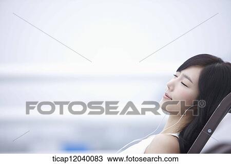 A woman listeing to a music with eyes closed View Large Photo Image Stock Image - A woman listeing to a music with eyes closed. Fotosearch