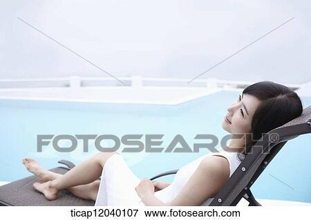 A woman lying on a sunbed View Large Photo Image Stock Photo - A woman lying on a sunbed. Fotosearch