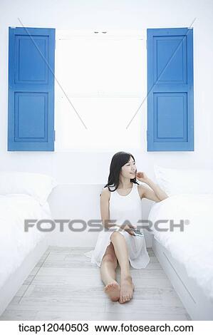A woman sitting between white beds View Large Photo Image Stock Image - A woman sitting between white beds. Fotosearch