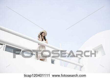 A woman wearing a white dress and straw hat leaning her hands on a fence View Large Photo Image Stock Image - A woman wearing a white dress and straw hat leaning her hands on a fence. Fotosearch
