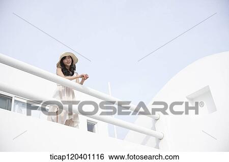 A woman wearing a white dress and straw hat leaning her hands on a white fence View Large Photo Image Stock Photograph - A woman wearing a white dress and straw hat leaning her hands on a white fence. Fotosearch