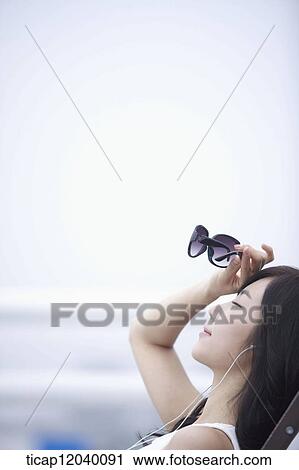 Stock Image - A woman with sunglasses in her hand . Fotosearch