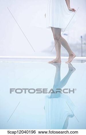 A woman without wearing shoes next to a pool View Large Photo Image Stock Photograph - A woman without wearing shoes next to a pool. Fotosearch