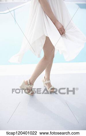 A woman's white dress being blown next to a pool View Large Photo Image Stock Image - A woman's white dress being blown next to a pool. Fotosearch