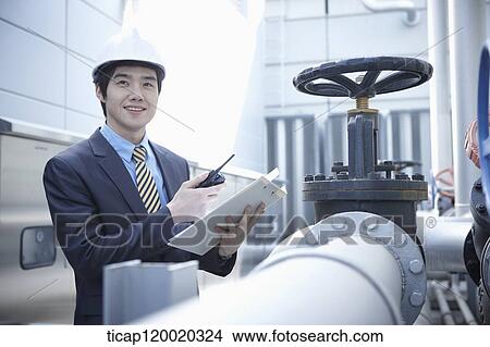 An architect standing next to a pipeline View Large Photo Image Picture - An architect standing next to a pipeline. Fotosearch