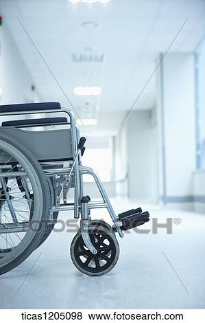 An empty wheelchair in a white hospital corridor View Large Photo Image Stock Photo - An empty wheelchair in a white hospital corridor . Fotosearch