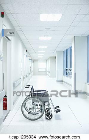 Picture - An empty wheelchair left in an empty hospital corridor. Fotosearch