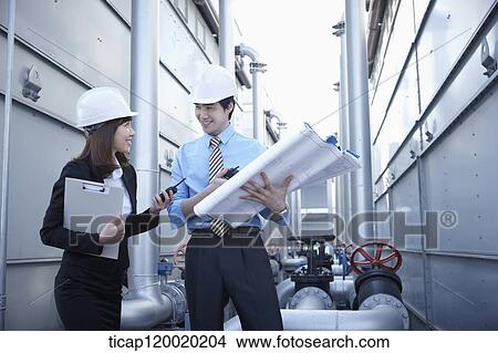 Architect engineers discussing while holding a portfolio and a report View Large Photo Image Picture - Architect engineers discussing while holding a portfolio and a report. Fotosearch