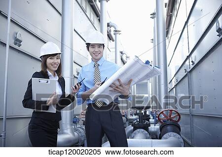 Stock Photography - Architect engineers smiling while holding a portfolio and a report. Fotosearch
