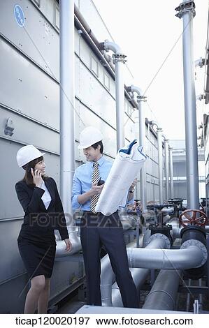 Stock Photo - Architects in hardhat talking to each other. Fotosearch