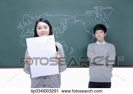 boy leaning against the blackboard and girl holding a paper View Large Photo Image Stock Image - boy leaning against the blackboard and girl holding a paper. Fotosearch