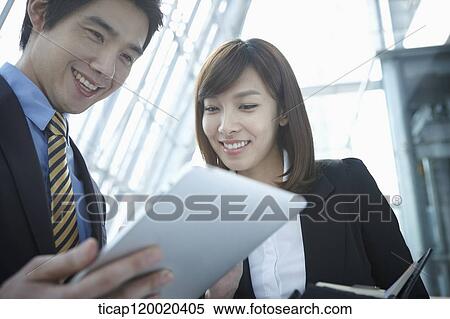 Businessman and woman looking at report View Large Photo Image Stock Photography - Businessman and woman looking at report . Fotosearch