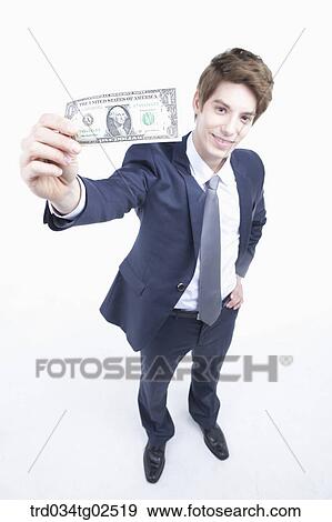 Stock Photo - businessman holding a dollar bill on his hand. Fotosearch