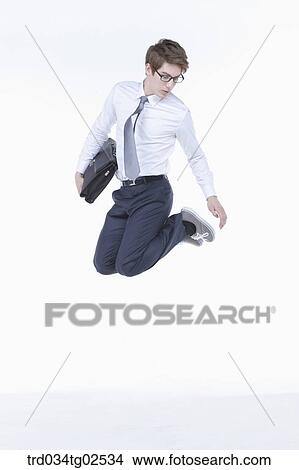 Picture - businessman jumping into the air. Fotosearch