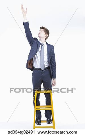 businessman reaching out his hand on the ladder View Large Photo Image Stock Image - businessman reaching out his hand on the ladder. Fotosearch