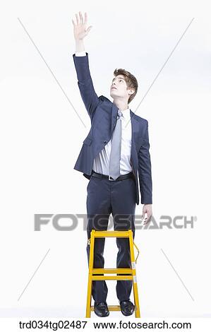 businessman reaching out his hand on the ladder View Large Photo Image Stock Photo - businessman reaching out his hand on the ladder. Fotosearch