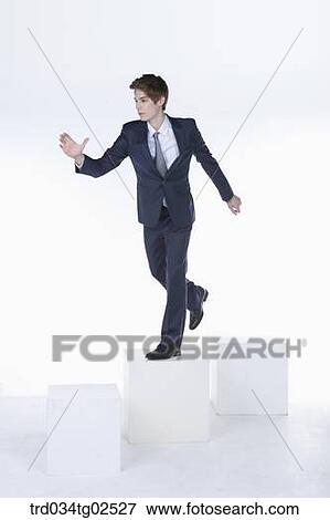 Stock Photo - businessman standing on the box and reaching out his hand. Fotosearch