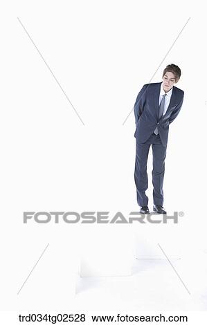 businessman standing on the box and bending his body View Large Photo Image Stock Photo - businessman standing on the box and bending his body. Fotosearch