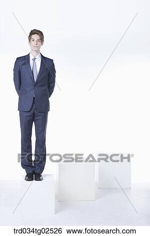 businessman standing on the box with his hands clasped behind his back View Large Photo Image Stock Photograph - businessman standing on the box with his hands clasped behind his back. Fotosearch