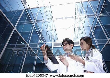 Docors in a modern building with a report View Large Photo Image Stock Photo - Docors in a modern building with a report . Fotosearch