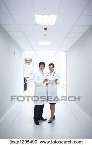 Doctors in white dressing gown standing in a hospital corridor View Large Photo Image Stock Image - Doctors in white dressing gown standing in a hospital corridor. Fotosearch