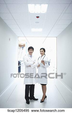 Doctors in white dressing gown standing in a hospital corridor View Large Photo Image Stock Photography - Doctors in white dressing gown standing in a hospital corridor. Fotosearch