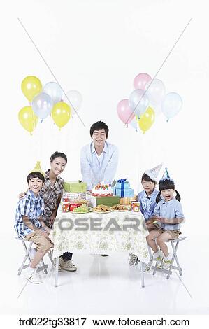 Stock Photo - family having a birthday party. Fotosearch