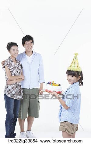 father and mother looking at daughter holding a birthday cake View Large Photo Image Picture - father and mother looking at daughter holding a birthday cake . Fotosearch