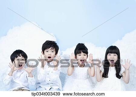 Stock Photo - four kids with looks of angels on the clouds. Fotosearch